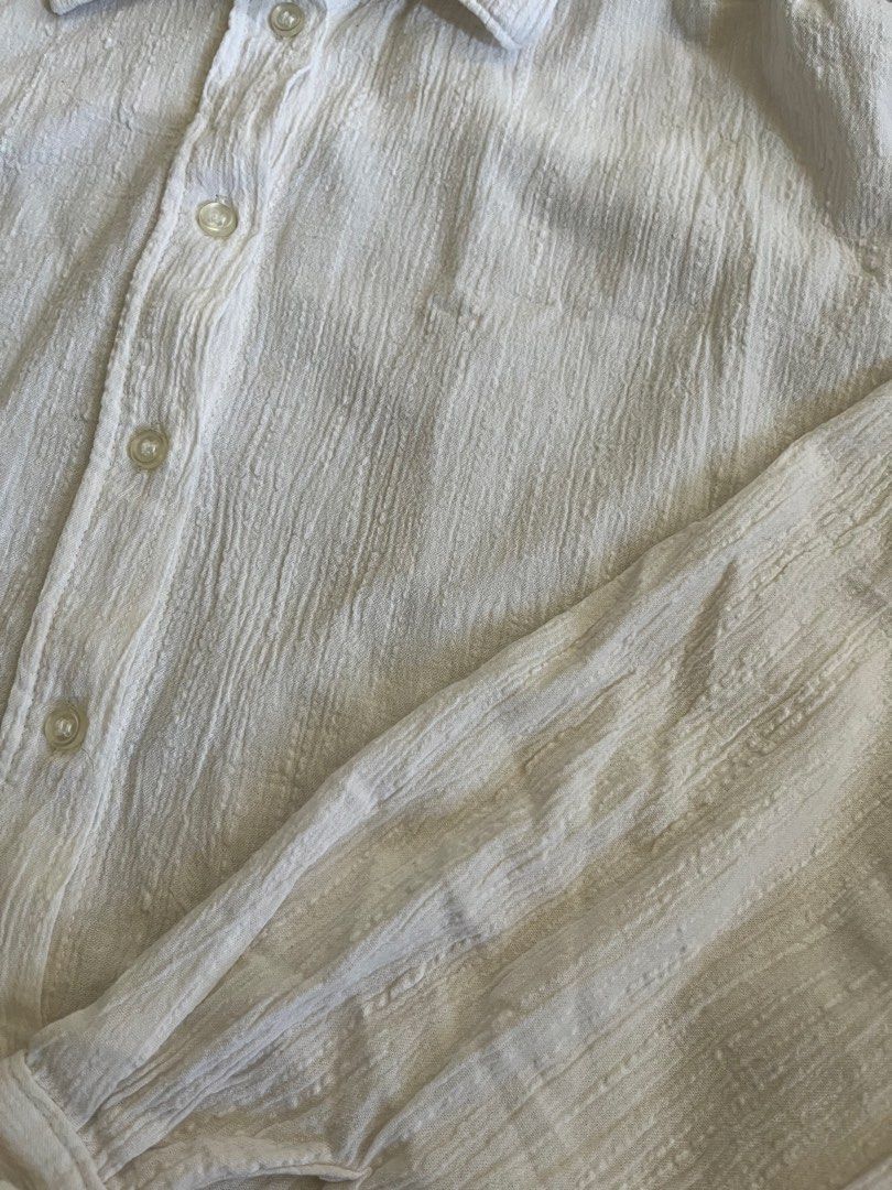 H&M White Textured Button-Down Shirt (XS) (Category: Shirts) located in Subic. Submitted by yuridecluttersxz (Listing ID 1466806447, Image 3). Description: H&M Textured Button-down - Brand: H&M - Size: Extra Small (XS) - Material: 100% cotton - Color: White with subtle vertical textured patterns - Features: Long sleeves with button cuffs, classic collar, curved hem - Condition: Has minor small stains Extra button still intact Shipping: Delivery v