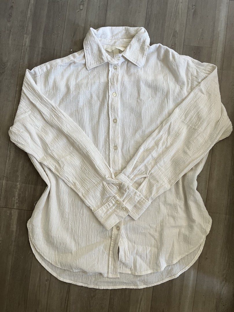 H&M White Textured Button-Down Shirt (XS) (Category: Shirts) located in Subic. Submitted by yuridecluttersxz (Listing ID 1466806447, Image 1). Description: H&M Textured Button-down - Brand: H&M - Size: Extra Small (XS) - Material: 100% cotton - Color: White with subtle vertical textured patterns - Features: Long sleeves with button cuffs, classic collar, curved hem - Condition: Has minor small stains Extra button still intact Shipping: Delivery v