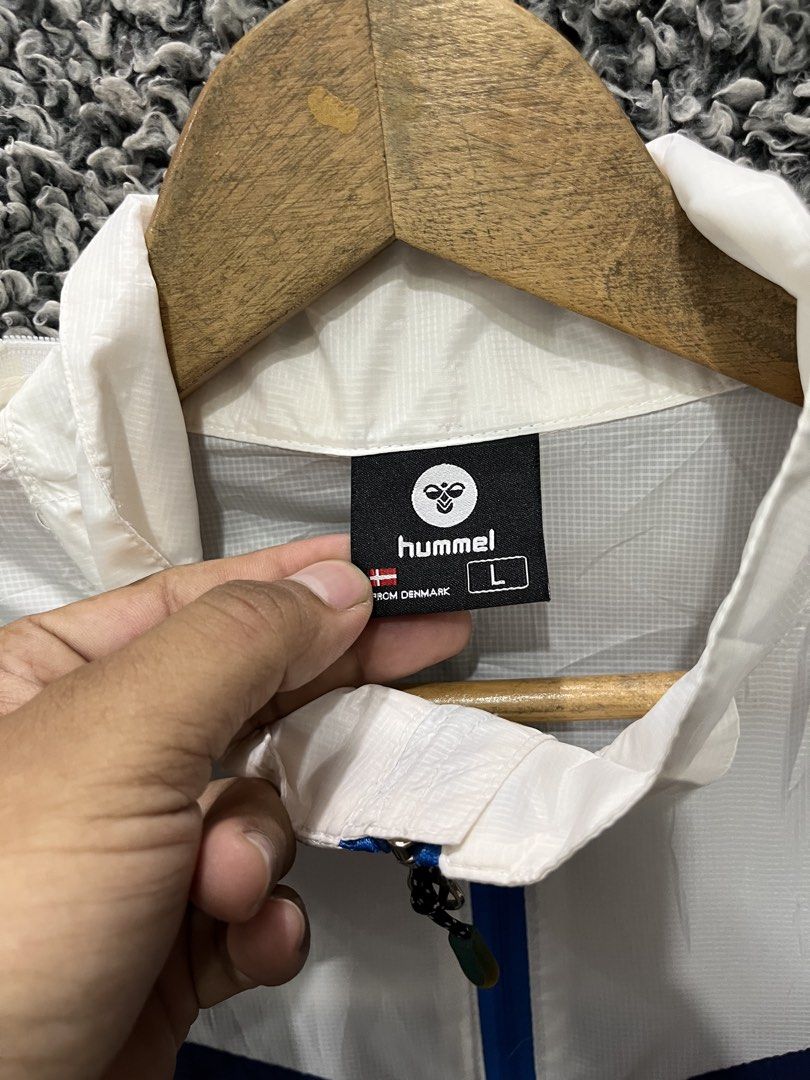Hummel Hyper Technical colorblock windbreaker jacket. | Size L (Category: Coats, Jackets and Outerwear) located in General Trias. Submitted by zrchustle.604 (Listing ID 1466970582, Image 2). Description: Hummel Hyper Technical colorblock windbreaker jacket. It features a prominent blue, white, and gray geometric panel design, a full-zip front closure, zippered hand pockets with bright blue contrast trim, and a high collar that houses a packable h