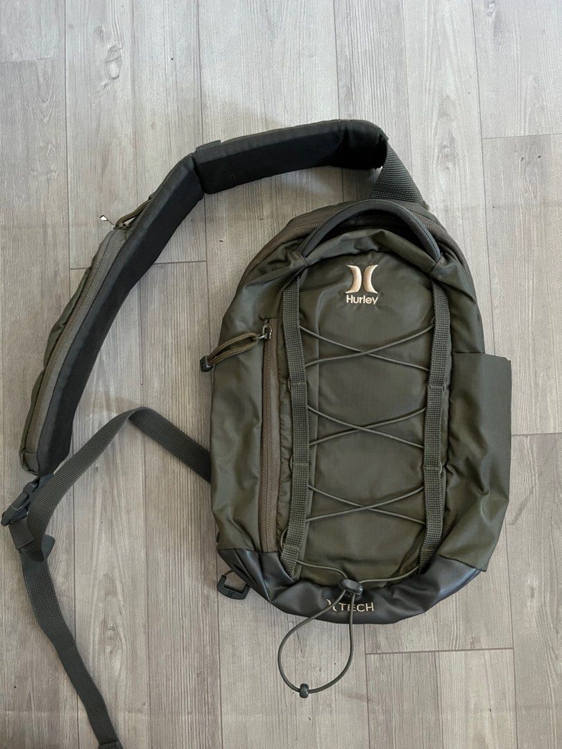 Hurley Olive Green Crossbody Bag (Category: Sling Bags) located in Subic. Submitted by yuridecluttersxz (Listing ID 1466808145, Image 1). Description: Hurley Crossbody Bag in Olive Green - Brand: Hurley - Color: Olive green - Condition: with small rip - Compartments: Zippered main compartment with inner slip and mesh zip pockets - Exterior: Front pocket with cord bungee system - Strap: Adjustable and padded, featuring a small attached zippered po