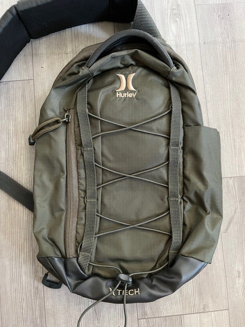 Hurley Olive Green Crossbody Bag (Category: Sling Bags) located in Subic. Submitted by yuridecluttersxz (Listing ID 1466808145, Image 2). Description: Hurley Crossbody Bag in Olive Green - Brand: Hurley - Color: Olive green - Condition: with small rip - Compartments: Zippered main compartment with inner slip and mesh zip pockets - Exterior: Front pocket with cord bungee system - Strap: Adjustable and padded, featuring a small attached zippered po