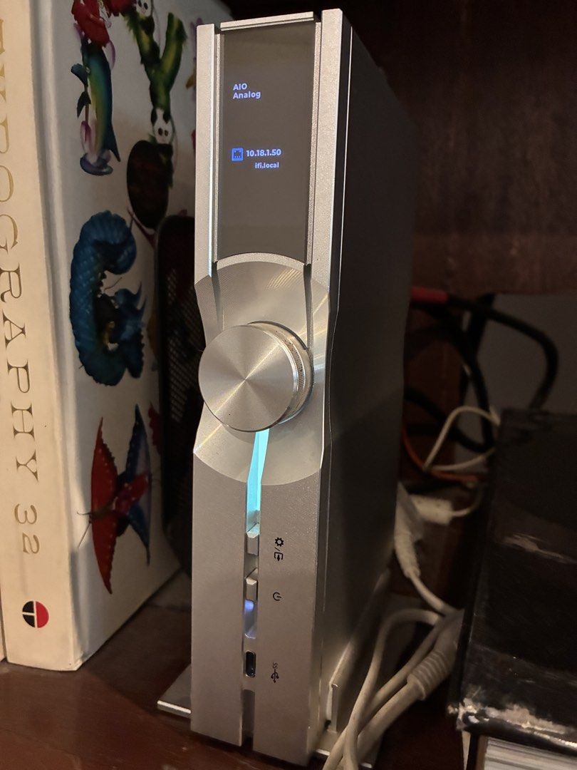 iFi NEO Stream - audio Network Streamer DAC (Category: Soundbars, Speakers & Amplifiers) located in Muntinlupa City. Submitted by migmari (Listing ID 1466813447, Image 2). Description: - Brand: iFi audio streamer - Color: Premium silver with a sturdy metal chassis - Design: Vertical standing with a large central volume knob - Display: Digital screen showing IP address and input status - Connectivity: Includes USB-C port, front panel buttons, and 