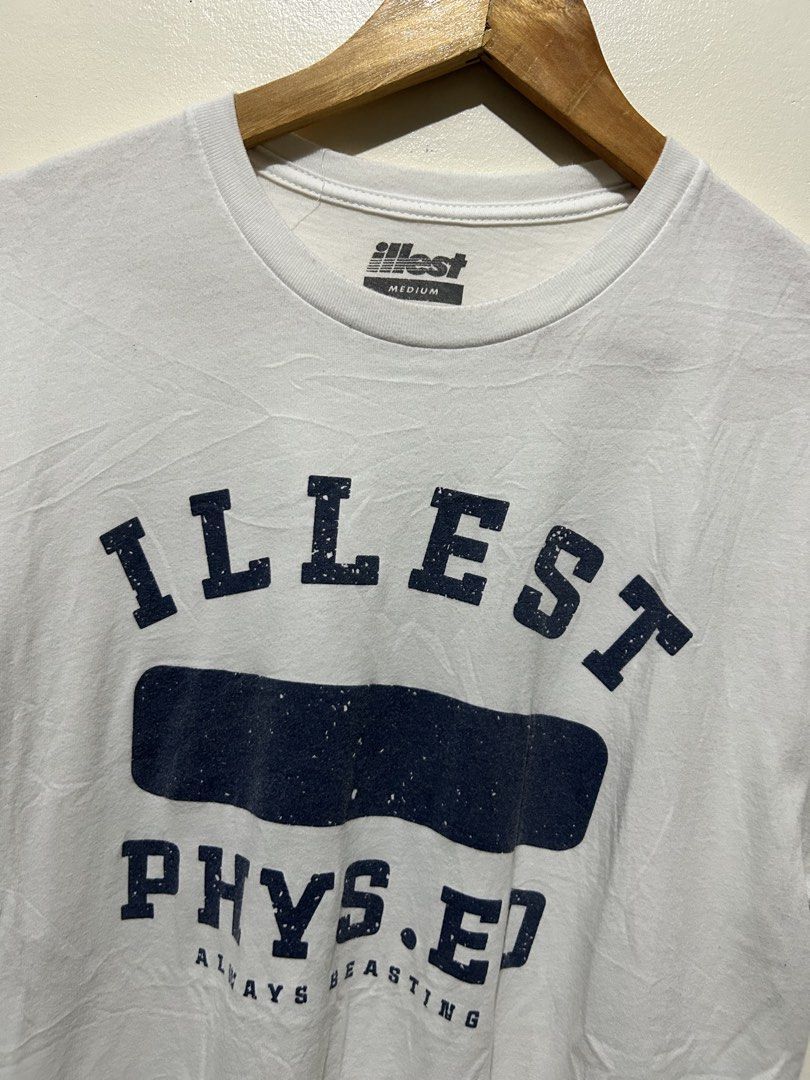 Illest Phys. Ed White T-Shirt Medium (Category: Tshirts & Polo Shirts ) located in Angeles City. Submitted by johngamboa (Listing ID 1466962222, Image 2). Description: - Brand/Style: White Illest Phys. Ed graphic t-shirt - Design: Navy blue distressed lettering on the chest with "always beasting" slogan - Size: Medium (tag on inner collar) - Material: 100% cotton, comfortable for daily wear - Fit/Cut: Crew neck, short sleeves - Vibe: Easy everyda