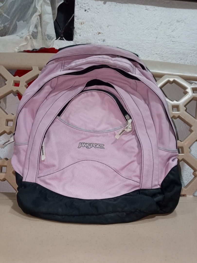 JanSport Pink and Black Backpack (Category: Backpacks) located in Manila. Submitted by caaths_collection (Listing ID 1466901447, Image 2). Description: - Brand: JanSport - Color: Pink and Black - Storage: Multiple compartments and zippered pockets - Durability: Sturdy canvas bottom panel - Made in China with interior care and manufacture tags.