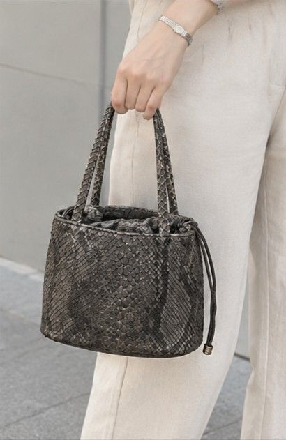 📣ON SALE‼️FROM 4800 TO 4200‼️JAPAN TSUKIOKAMOTO GENUINE REAL AUTHENTIC PYTHON SNAKESKIN SMALL BUCKET BAG HANDBAG (Category: Luxury Bags & Wallets) located in Quezon City. Submitted by sparkys.joy_88 (Listing ID 1466883147, Image 2). Description: - Brand: Tsukiokamoto - Material: Genuine python snakeskin with natural scale texture - Color: Grey and dark tones - Design: Bucket bag style with dual top handles and inner drawstring pouch - Condition: