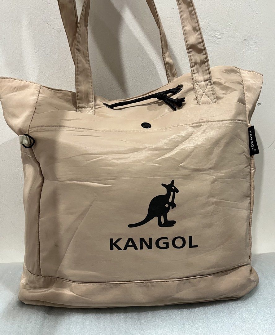 Kangol beige nylon tote bag with drawstring (Category: Tote Bags) located in Talisay. Submitted by cherylu (Listing ID 1466937175, Image 1). Description: Beige Kangol tote bag in nylon material. Black kangaroo logo printed on the front. Drawstring closure mechanism at the top. Dual shoulder straps for carrying. Inside features a fabric brand patch and a zippered pocket. Spacious interior compartment with a structured bottom base..