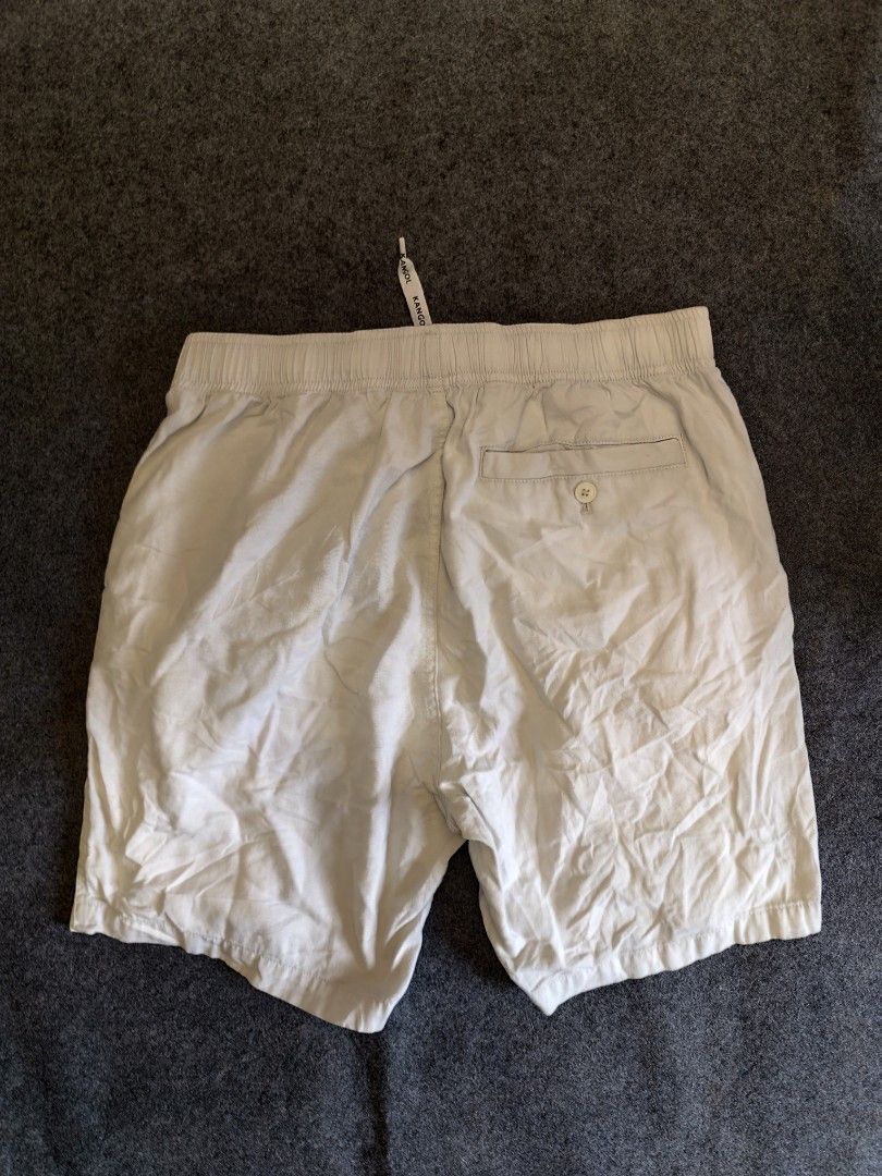 Kangol White Drawstring Shorts Size XL (Category: Shorts) located in Cordova. Submitted by bsb.streetluxvintage.clothing (Listing ID 1466860399, Image 2). Description: - Brand: Kangol - Color: White - Size: XL - Waistband: Elastic with branded drawstring cords - Pockets: Two front pockets and one back pocket with button closure - Details: Embroidered kangaroo logo on the left leg hem - Condition: Comfortable casual wear, shows normal signs of pre