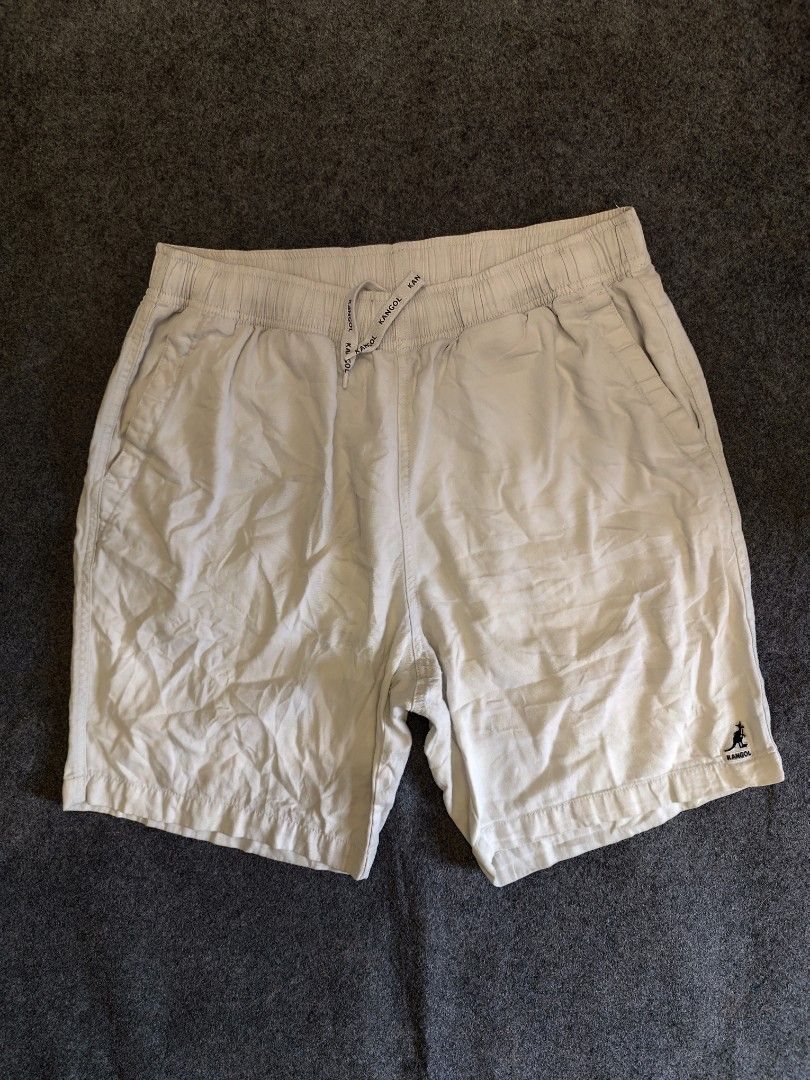 Kangol White Drawstring Shorts Size XL (Category: Shorts) located in Cordova. Submitted by bsb.streetluxvintage.clothing (Listing ID 1466860399, Image 1). Description: - Brand: Kangol - Color: White - Size: XL - Waistband: Elastic with branded drawstring cords - Pockets: Two front pockets and one back pocket with button closure - Details: Embroidered kangaroo logo on the left leg hem - Condition: Comfortable casual wear, shows normal signs of pre