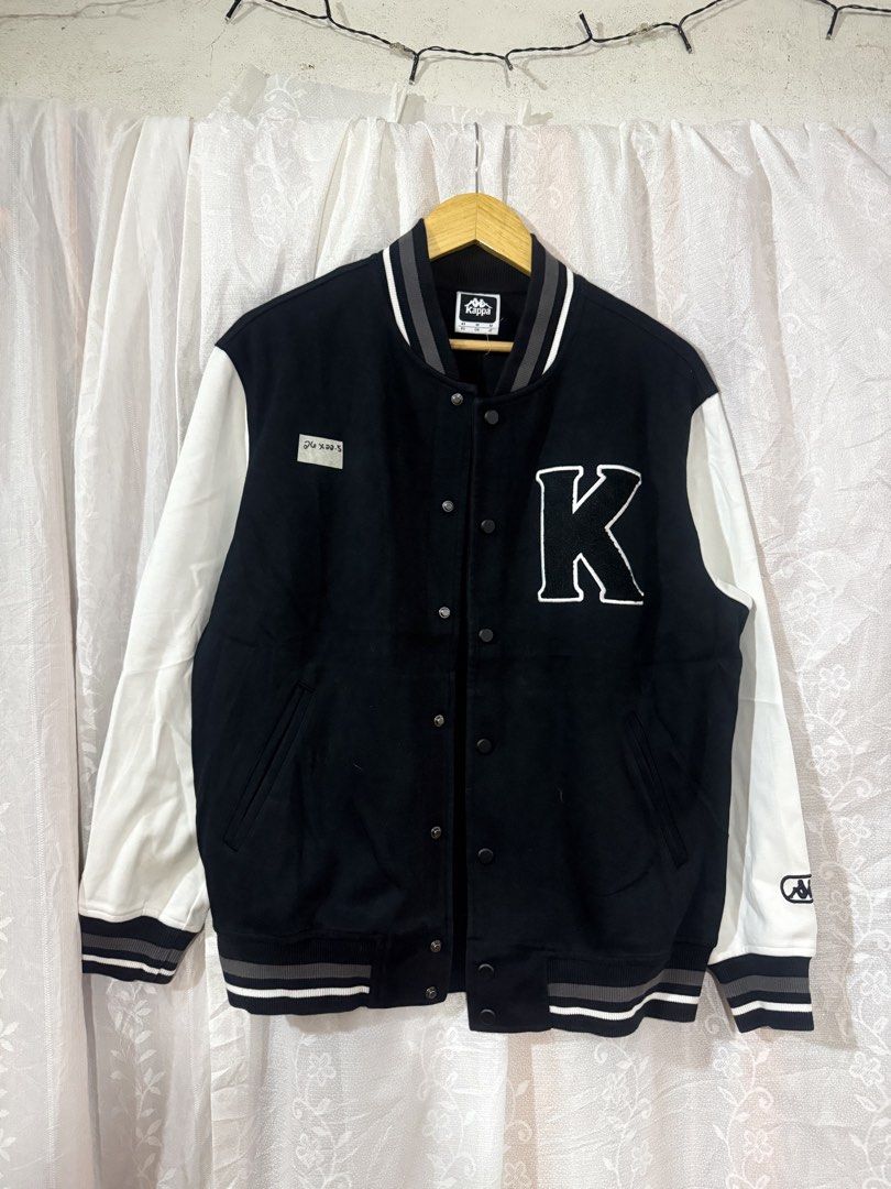 Kappa Black and White Varsity Jacket (Category: Coats, Jackets and Outerwear) located in Quezon City. Submitted by dapanaaaay (Listing ID 1466883675, Image 1). Description: - Brand: Kappa - Style: Black and white varsity jacket - Closure: Classic front snap buttons - Details: Large embroidered white 'K' patch on chest, Kappa logo patch near left cuff - Accents: Black, grey, and white striped ribbed collar, cuffs, and hem - Sleeves: Contrasting wh
