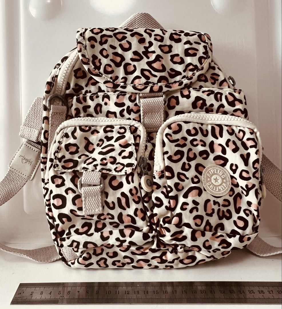Kipling Leopard Print Mini Backpack (Category: Backpacks) located in Singapore. Submitted by knight2000 (Listing ID 1466825949, Image 1). Description: - Brand/Style: Kipling everyday shoulder bag - Pattern: Fun leopard print (cream background with black and pinkish spots) - Storage: Multiple zipped front pockets and a main flap closure compartment - Straps: Adjustable beige canvas shoulder straps for a comfortable fit - Details: Signature round K