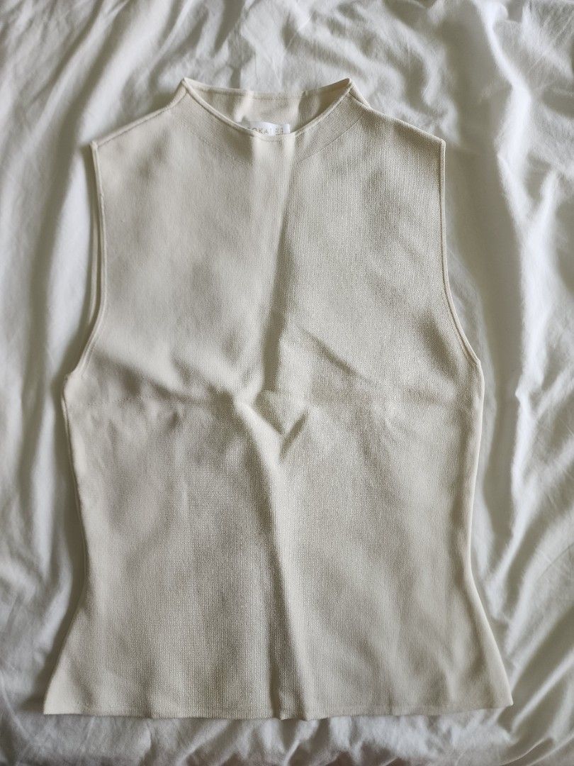 Kookai Off-White Knit Sleeveless Top (Category: Sleeveless) located in Cebu City. Submitted by groovefunknsoul (Listing ID 1466862329, Image 3). Description: - Brand: Kookai - Style: Sleeveless knit top with mock neck and fitted cut - Color: Off-white (solid neutral) - Size: AU 10 / FR 38 - Condition: Good, with a small pull near the lower back (please check close-up photo) - Versatile piece, perfect for layering or wearing on its own.