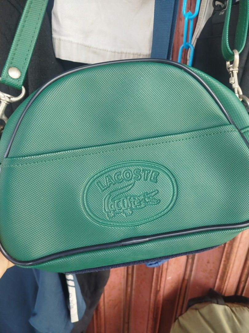 Lacoste Green Crossbody Bag (Category: Cross-body Bags) located in Davao. Submitted by vernoneighty4 (Listing ID 1466853799, Image 1). Description: - Brand: Lacoste - Style: Structured crossbody dome bag - Color: Green - Closure: Top zipper with metal hardware - Exterior: Debossed crocodile logo on front pocket, Paris label on back - Strap: Adjustable green strap with metal clasps - Interior: Dark lining with an open slip pocket - Condition: Clea