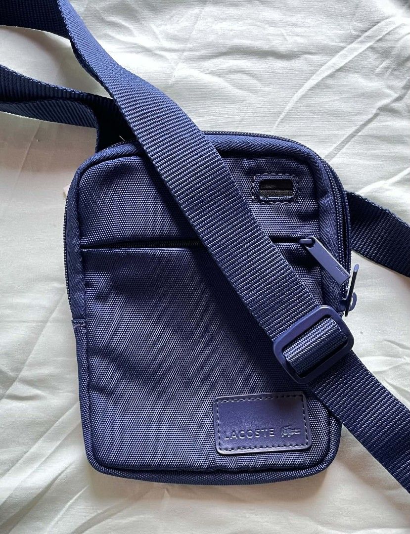 Lacoste Navy Blue Crossbody Bag (Category: Cross-body Bags) located in Manila. Submitted by xtinamendo00659 (Listing ID 1466836448, Image 1). Description: - Authentic navy blue Lacoste crossbody bag made from durable nylon - Adjustable shoulder strap for a comfortable, custom fit - Secure main compartment and front zip pocket with branded zipper pulls - Features the classic rectangular Lacoste logo patch on the front - Impeccably clean interior a