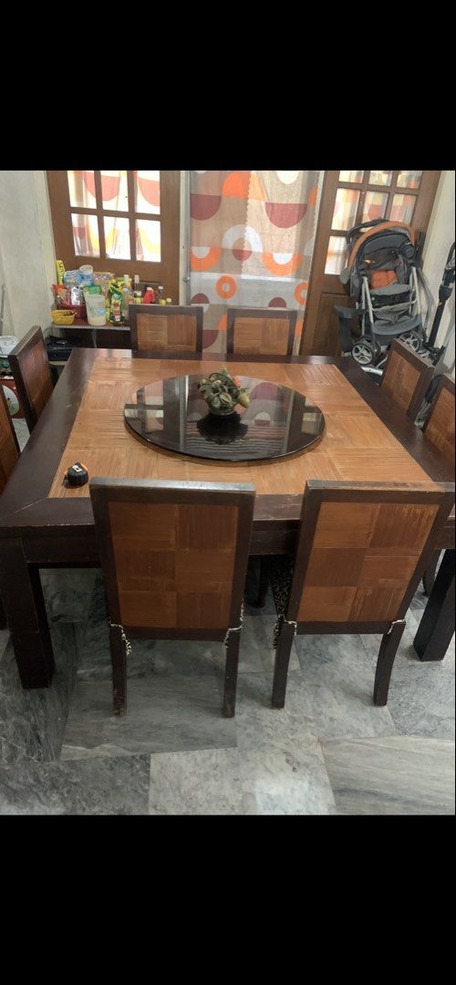 Large Wooden Dining Table with 8 Leopard Print Chairs (Category: Tables & Sets) located in Manila. Submitted by samsongarcia (Listing ID 1466889433, Image 1). Description: Big square wooden dining table with a dark brown outer frame, parquet top pattern, and a revolving black lazy Susan glass tray in the middle. Includes eight matching dining chairs with checkerboard wooden backs and leopard print fabric seats. Sturdy setup, seats a large family 