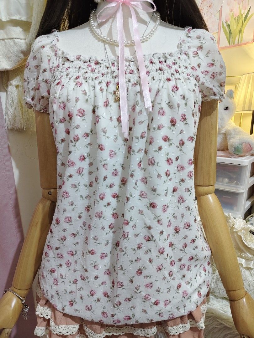 L'est Rose Floral Off-Shoulder Top (Category: Blouses) located in Manila. Submitted by chynii_28 (Listing ID 1466867370, Image 3). Description: - Brand: L'est Rose - Design: White floral blouse with small pink roses and subtle dot texture - Details: Square neckline, short puff sleeves, and comfortable smocked elastic chest - Fit: Flowy drape, fits bust 32 to 38 inches and waist up to 38 inches - Condition: 10/10, zero flaws found.