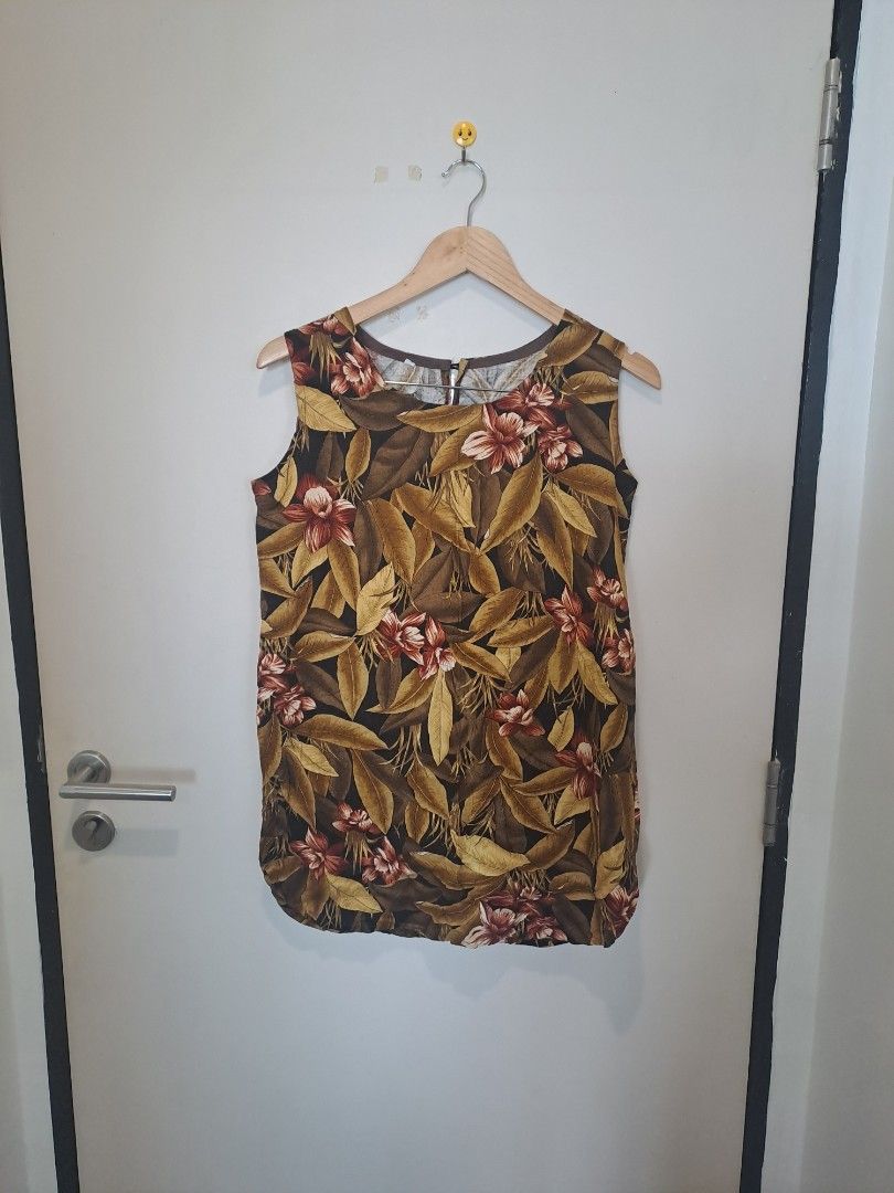 Linen tropical sleeveless (Category: Others Tops) located in Manila. Submitted by joanbalde39643 (Listing ID 1466839376, Image 1). Description: This is a sleeveless tropical blouse featuring an all-over botanical print with lush autumn-toned leaves, palms, and hibiscus flowers in shades of olive green, warm brown, tan, and dark burgundy. Designed with a classic round neckline and a fluid, comfortable drape, this type of shift top or tunic is perf