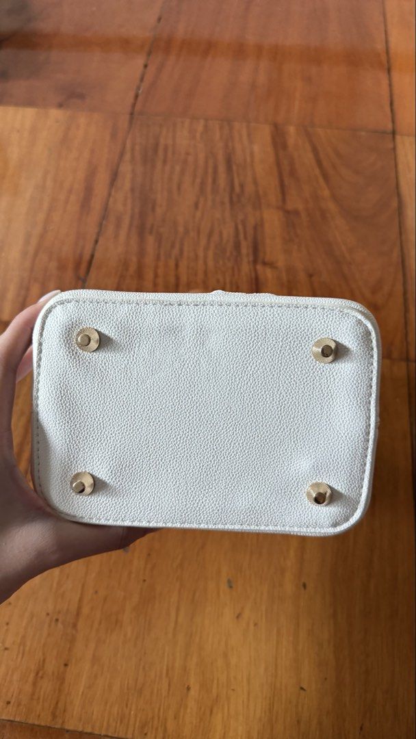 Locally made hand bucket bag (Category: Cross-body Bags) located in Makati City. Submitted by thevault88 (Listing ID 1466859401, Image 3). Description: - Locally made white bucket bag - Stylish marbled acrylic top handle and matching frame - Secure kiss-lock closure - Includes detachable white shoulder/crossbody strap - Features protective metal feet at the bottom - Pre-loved condition rated 7/10.