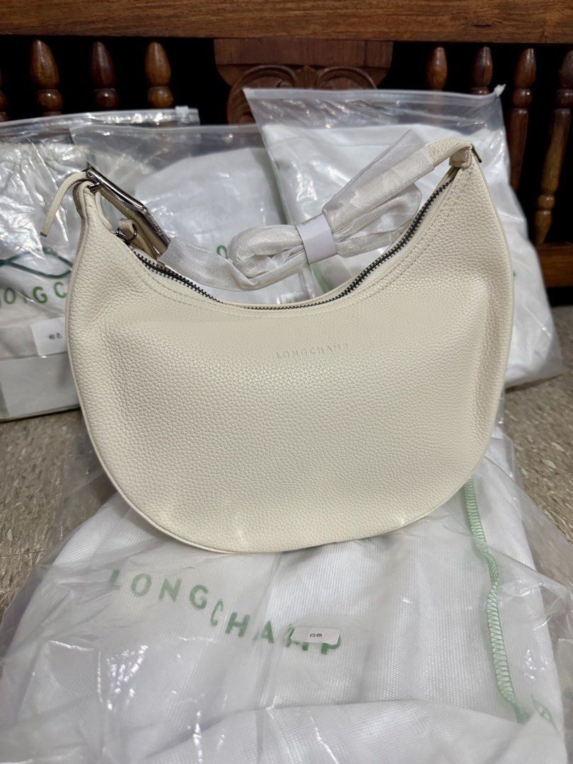 Longchamp White Leather Shoulder Bag (Category: Luxury Bags & Wallets) located in Imus. Submitted by avielicious (Listing ID 1466910932, Image 1). Description: - Authentic Longchamp crescent shoulder bag in white pebbled leather - Secure zippered top closure with chic metal hardware buckle strap - Includes original dust bag - Sleek, trendy silhouette perfect for everyday use or special occasions.