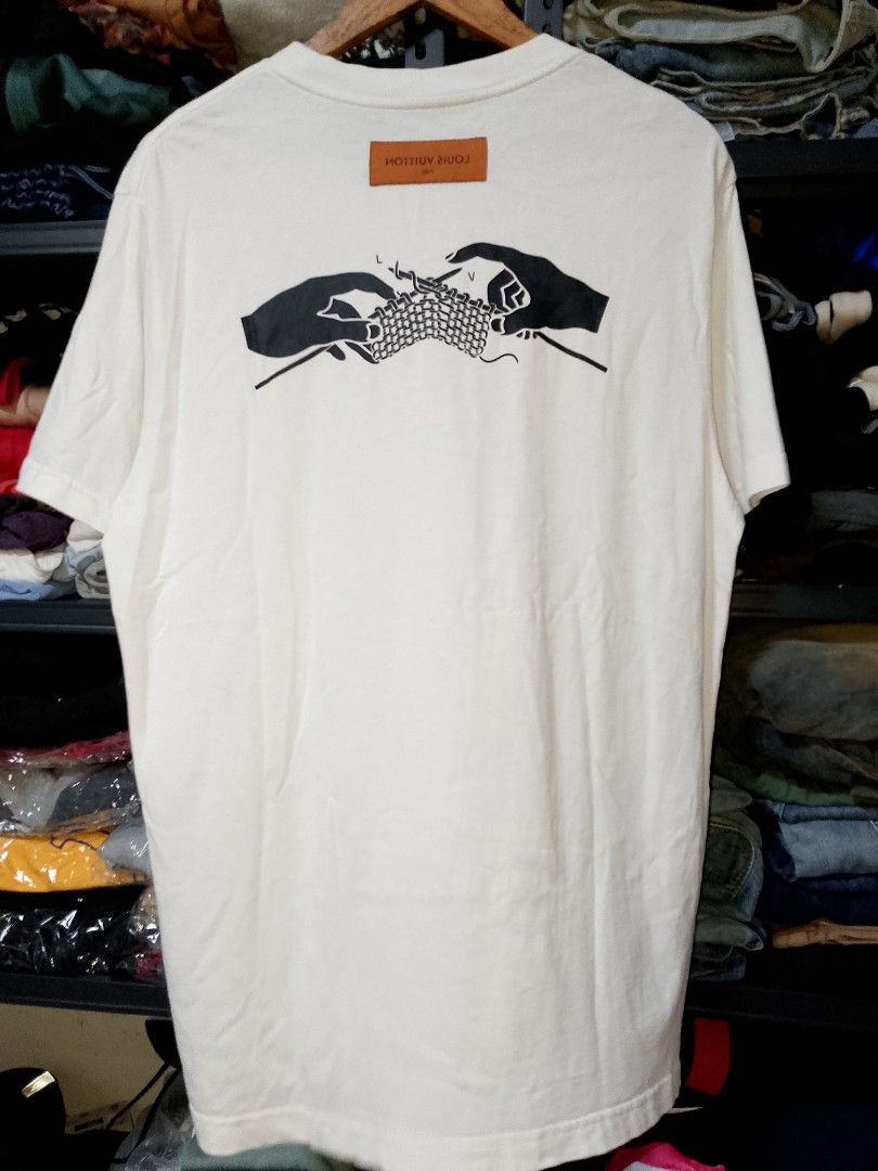 Louis Vuitton Cable Pattern T-shirt White Size L (Category: Tshirts & Polo Shirts ) located in Manila. Submitted by mjthrifted_second (Listing ID 1466840641, Image 2). Description: Louis Vuitton white t-shirt, cable pattern text printed on the front. Hands knitting graphic printed on the back with an orange leather brand tag near the collar. Made in Italy, size L. Clean fabric, collar tags intact. Size Large Dimes 22/29.
