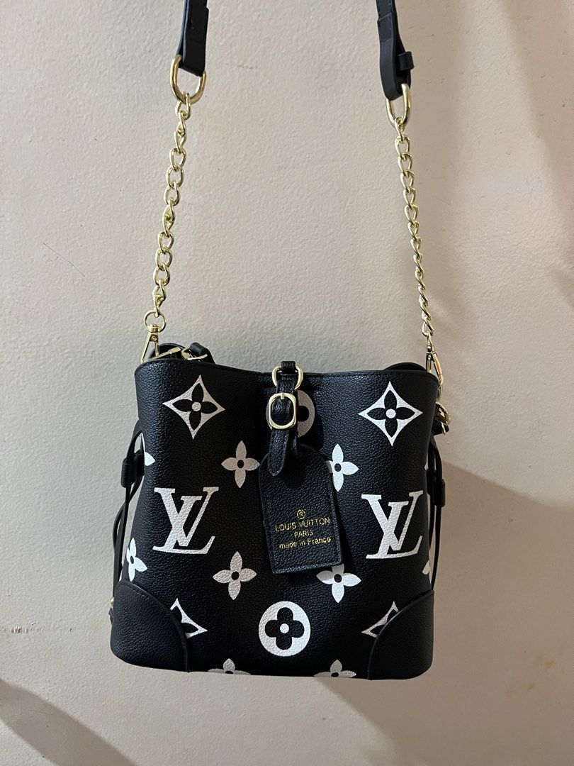 Louis Vuitton Monogram Empreinte Leather Bucket Bag (Category: Luxury Bags & Wallets) located in Tubigon. Submitted by gypsea.soulph (Listing ID 1466948336, Image 2). Description: - Style: Black leather bucket bag with white LV monogram and floral motifs - Hardware: Gold-tone hardware with a stylish chain strap - Features: Structured shape, corner reinforcement patches, front buckle strap detail, and a branded luggage tag - Condition: Clean inter