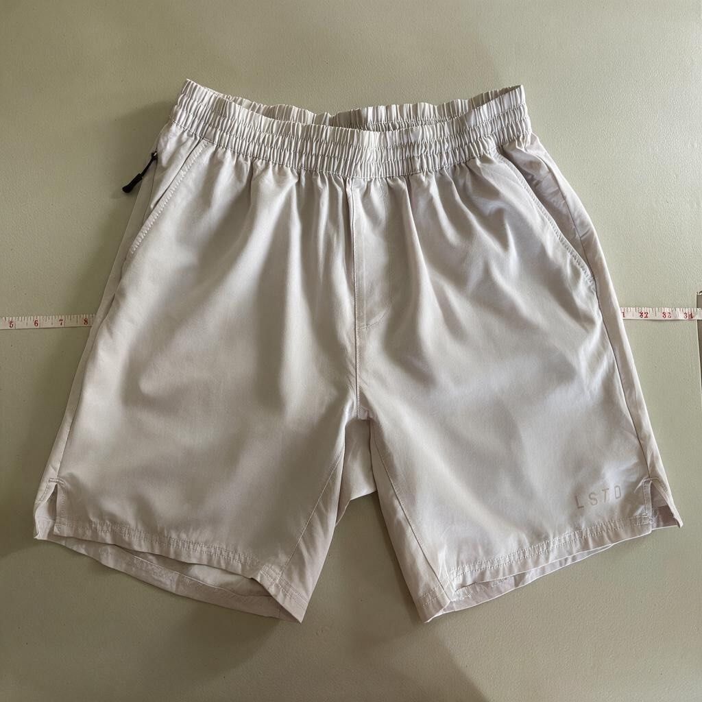 LSKD running shorts (Category: Activewear) located in Iloilo. Submitted by oddforest.c9c7d5 (Listing ID 1466809497, Image 2). Description: - Brand/Model: LSKD Athletic Shorts - Size: MED-LARGE - Color: Light Grey with black drawstring - Material: Lightweight technical fabric - Features: Secure zipped side pockets & elastic waistband - Detail: Small motivational quote printed near the hem - Condition: Clean, great for workouts or casual wear.