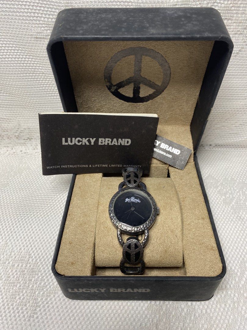 Lucky Brand watch (Category: Women's Watches) located in Angeles City. Submitted by noagrace (Listing ID 1466786315, Image 1). Description: A Lucky Brand women’s silver-tone peace sign watch featuring a black dial and a hammered metal link bracelet. Complete with box Normal signs of use No battery P1000.