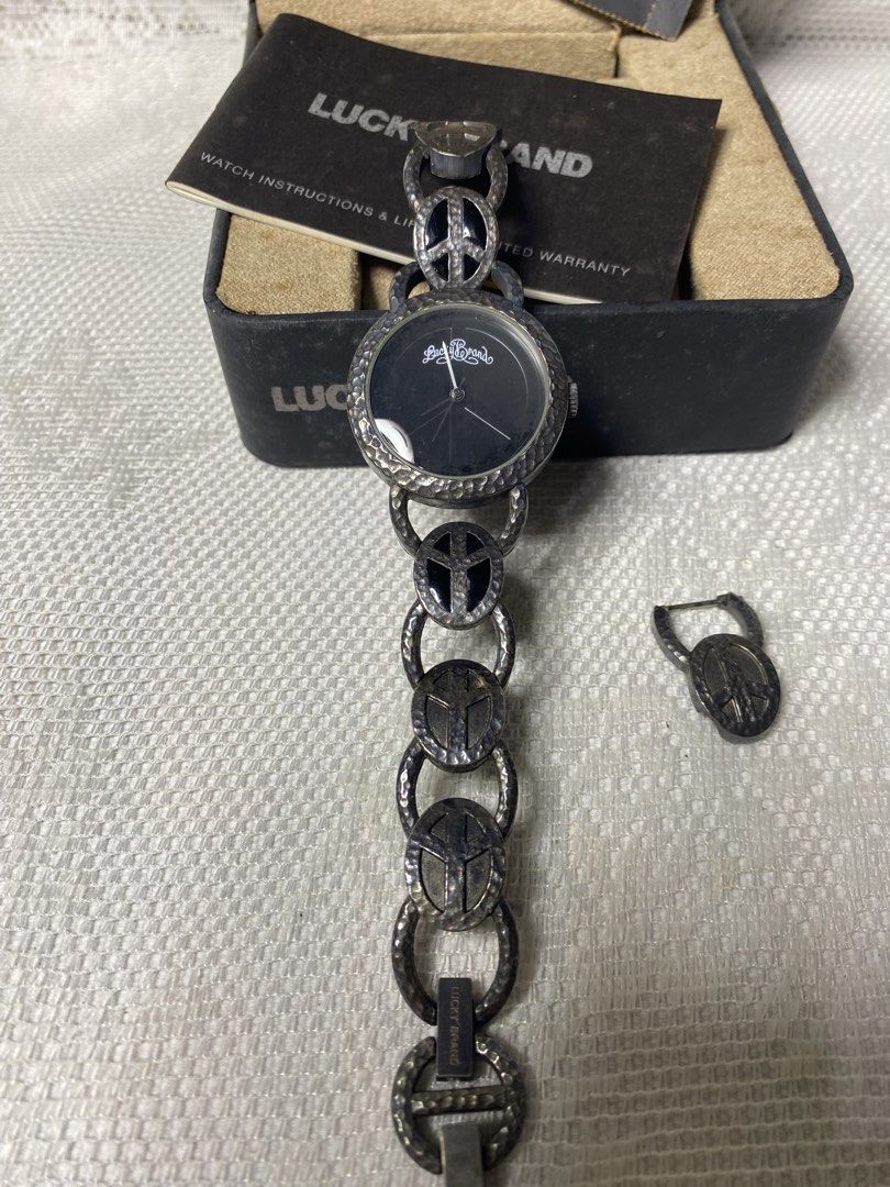 Lucky Brand watch (Category: Women's Watches) located in Angeles City. Submitted by noagrace (Listing ID 1466786315, Image 2). Description: A Lucky Brand women’s silver-tone peace sign watch featuring a black dial and a hammered metal link bracelet. Complete with box Normal signs of use No battery P1000.