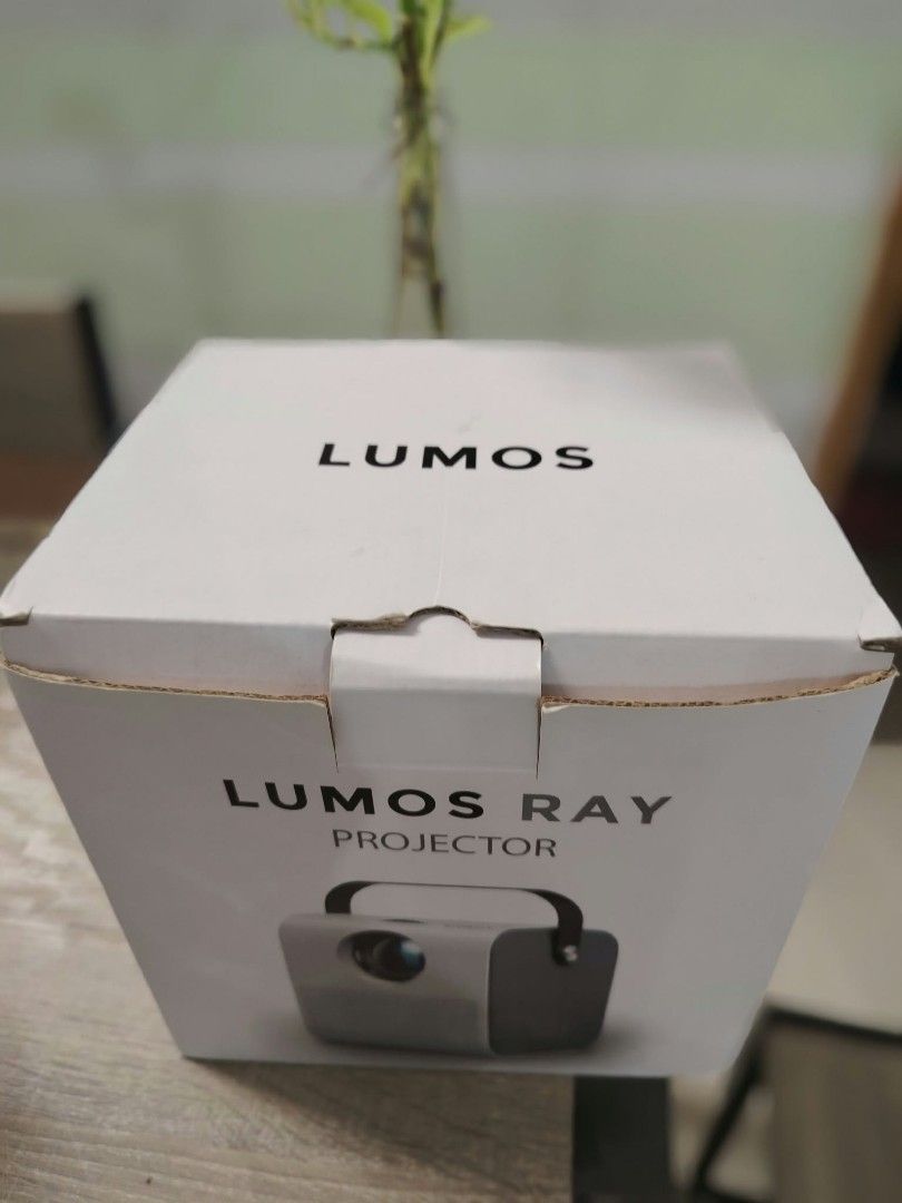 LUMOS Ray Projector (Category: Projectors) located in Manila. Submitted by cashcarti1111 (Listing ID 1466866066, Image 2). Description: - Brand: LUMOS Ray Projector (White with black carrying strap) - Condition: Tested and 100% working, perfect for home movie nights - Inclusions: Remote control, power cable, HDMI cable, AV cable, batteries, and user manual - Packaging: Comes with original box - Reason for selling: Decluttering (ready to ship or m