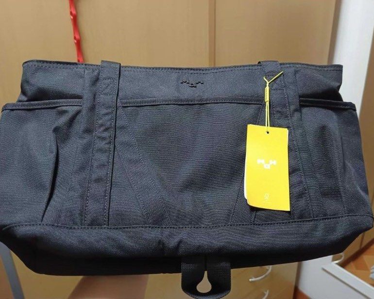 MAH Black Tour Tote Bag (Category: Tote Bags) located in Rizal. Submitted by prelovedthreadsss (Listing ID 1466945773, Image 1). Description: - Brand: MAH - Color: Solid black - Condition: Brand new with original tag and branded yellow packaging - Features: Secure top zipper closure, sturdy fabric handles, multiple inner and outer slip pockets for easy organization - Style: Minimalist and roomy, ideal for daily commuting or school.