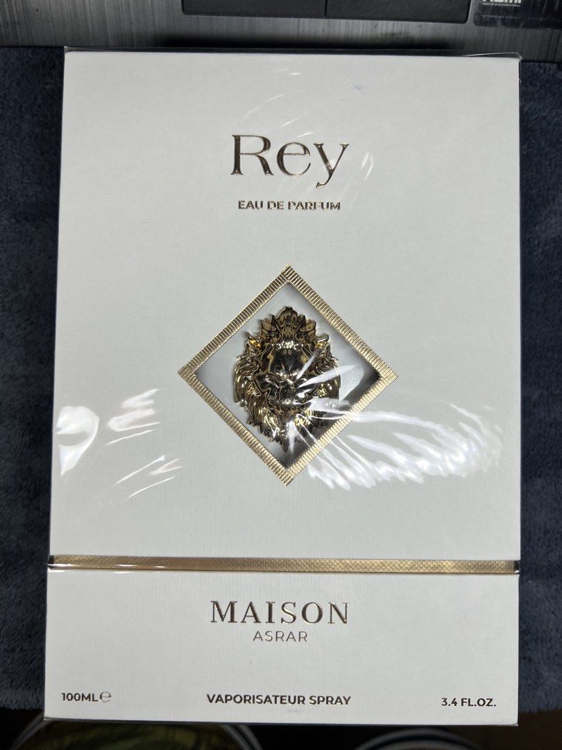 Maison Asrar Rey Eau de Parfum 100ml (Category: Fragrance & Deodorants) located in Manila. Submitted by l4ncedeleon (Listing ID 1466921722, Image 1). Description: - Brand: Maison Asrar (Rey) - Volume: 100ml / 3.4 fl. oz. - Condition: Brand new, factory-sealed in plastic with authentic holographic sticker - Packaging: White box with luxurious gold foil lettering and metallic lion emblem - Origin: Made in United Arab Emirates by Gulf Orchid Perfume