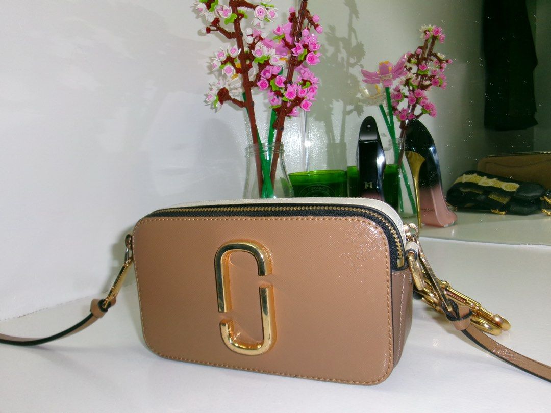Marc Jacobs Bag Brown White (Category: Luxury Bags & Wallets) located in Marikina City. Submitted by sheclothesandstilettos (Listing ID 1466863507, Image 2). Description: - Authentic Marc Jacobs Snapshot Camera Bag - Stylish brown and white color combination with luxury gold-tone hardware - Dual zip compartments to keep your daily essentials organized - Comes with two straps: an adjustable plain strap and a trendy wide patterned strap - Compact s