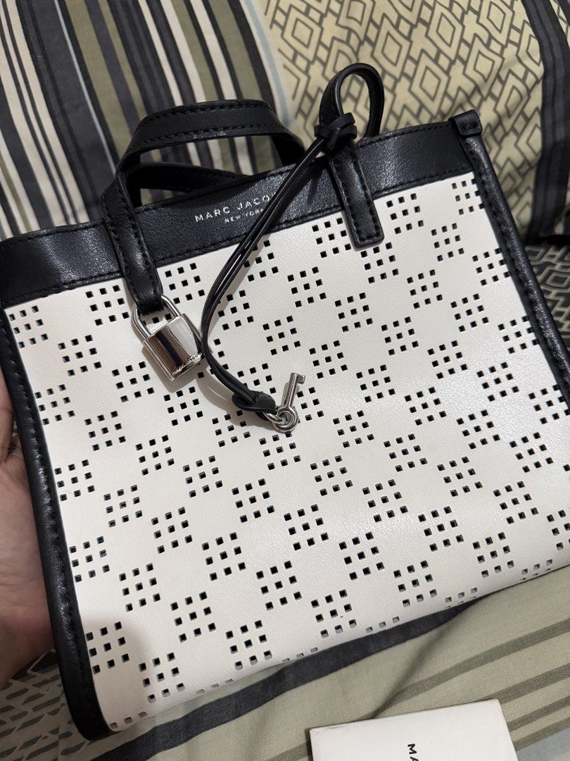 Marc Jacobs Black and White Perforated Tote Bag (Category: Tote Bags) located in Quezon City. Submitted by belleverzola (Listing ID 1466780285, Image 2). Description: - Like new with tag and card - Chic black and white perforated grid pattern - Includes matching front padlock and key accessory - Premium black leather dual top handles - Clean, structured shape designed for daily essentials.