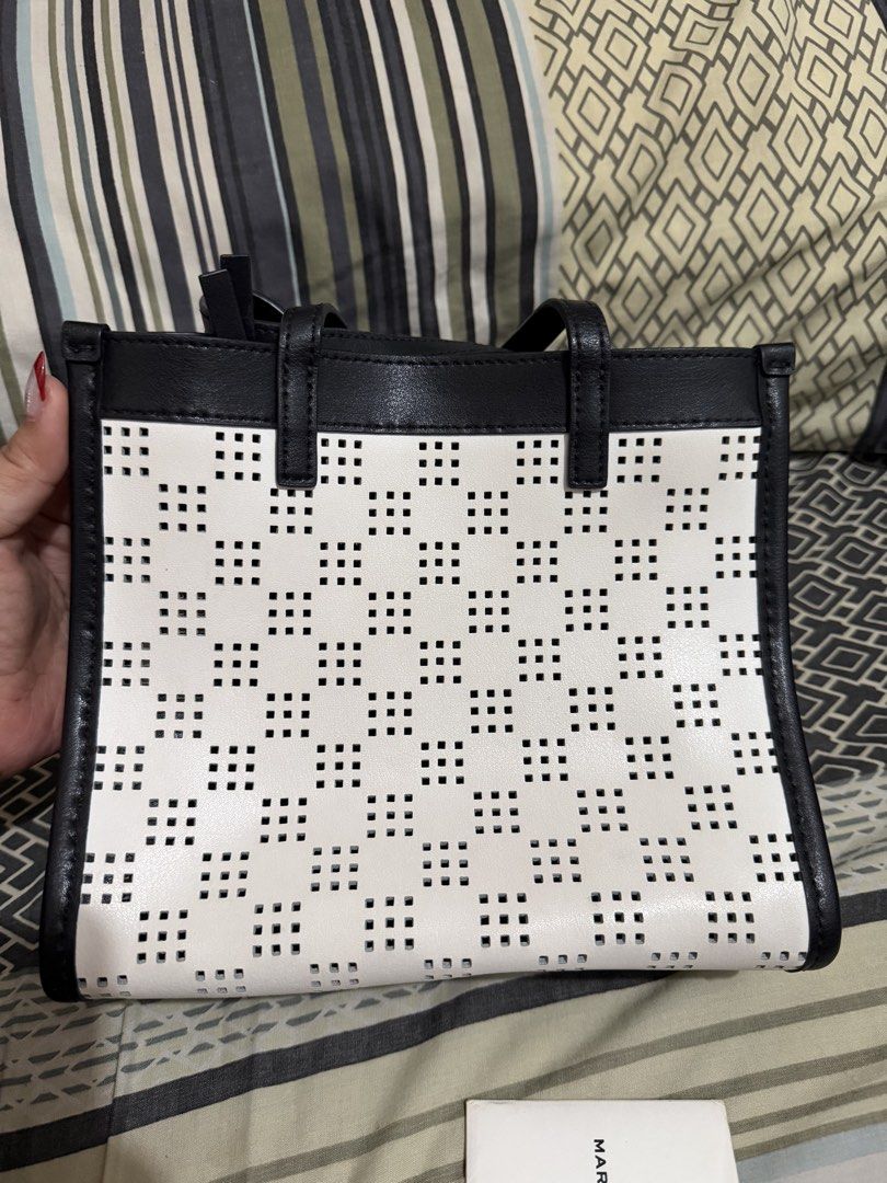 Marc Jacobs Black and White Perforated Tote Bag (Category: Tote Bags) located in Quezon City. Submitted by belleverzola (Listing ID 1466780285, Image 3). Description: - Like new with tag and card - Chic black and white perforated grid pattern - Includes matching front padlock and key accessory - Premium black leather dual top handles - Clean, structured shape designed for daily essentials.