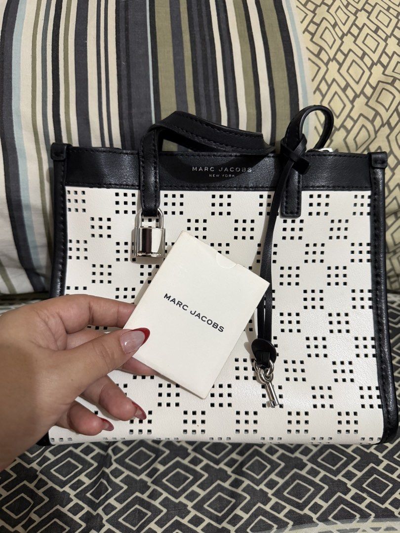 Marc Jacobs Black and White Perforated Tote Bag (Category: Tote Bags) located in Quezon City. Submitted by belleverzola (Listing ID 1466780285, Image 1). Description: - Like new with tag and card - Chic black and white perforated grid pattern - Includes matching front padlock and key accessory - Premium black leather dual top handles - Clean, structured shape designed for daily essentials.