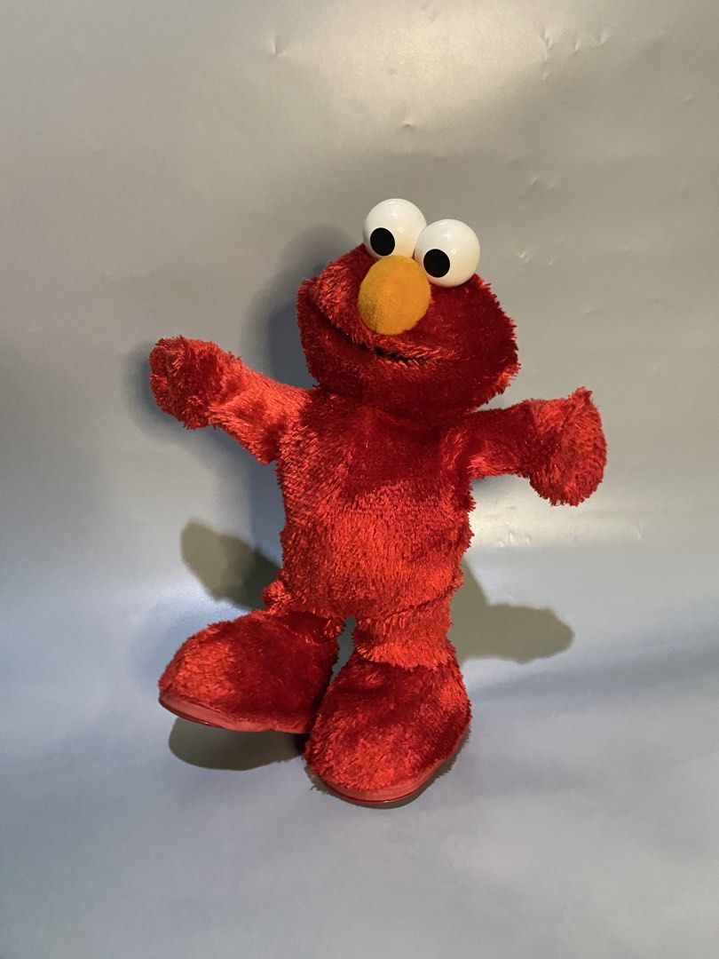 Mattel Sesame Workshop 2002 Elmo Interactive Toy (Category: Plushies & Soft Toys) located in Cebu City. Submitted by nardcen (Listing ID 1466882521, Image 1). Description: - Vintage 2002 Mattel and Sesame Workshop Elmo plush - Iconic red fuzzy body, big white googly eyes, and orange nose - Hard plastic feet with battery compartment (uses 4 AA batteries) - Features an active moving mechanism inside the base - Original back tag attached - Perfect f