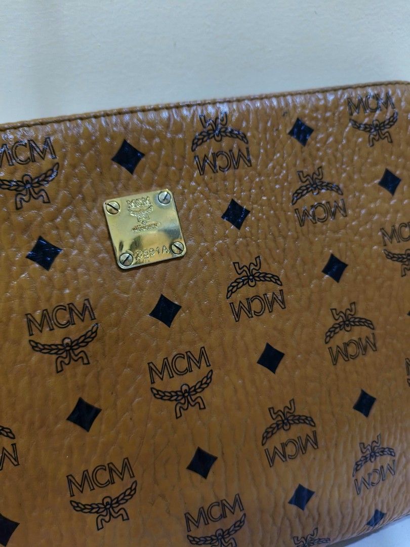 MCM Visetos Monogram Leather Pouch Clutch Bag Cognac (Category: Luxury Bags & Wallets) located in General Santos City (Dadiangas). Submitted by happyrabbit_42489c (Listing ID 1466909274, Image 2). Description: - Authentic MCM monogram pouch in classic cognac brown Visetos coated canvas - Accented with dark brown trim and polished gold-tone hardware - Secure zip-top closure with a clean fabric-lined interior - Includes a convenient inner slip pock