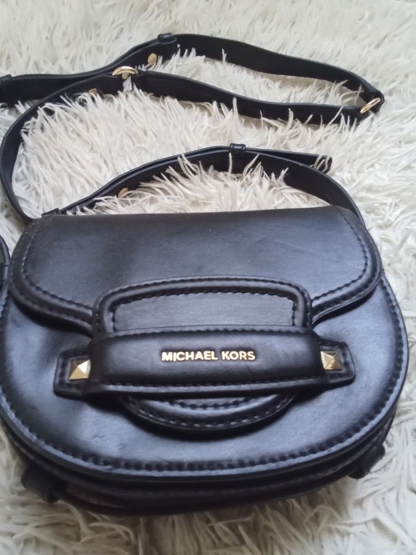 Michael Kors Black Crossbody Bag (Category: Cross-body Bags) located in Caloocan City. Submitted by noy5o1a (Listing ID 1466802577, Image 2). Description: - Brand: Michael Kors - Color: Classic Black - Material: Premium Leather - Hardware: Gold-tone with stylish stud accents - Design: Structured flap front with adjustable shoulder strap - Interior: Clean fabric lining with secure zipped pocket and embossed logo tag .