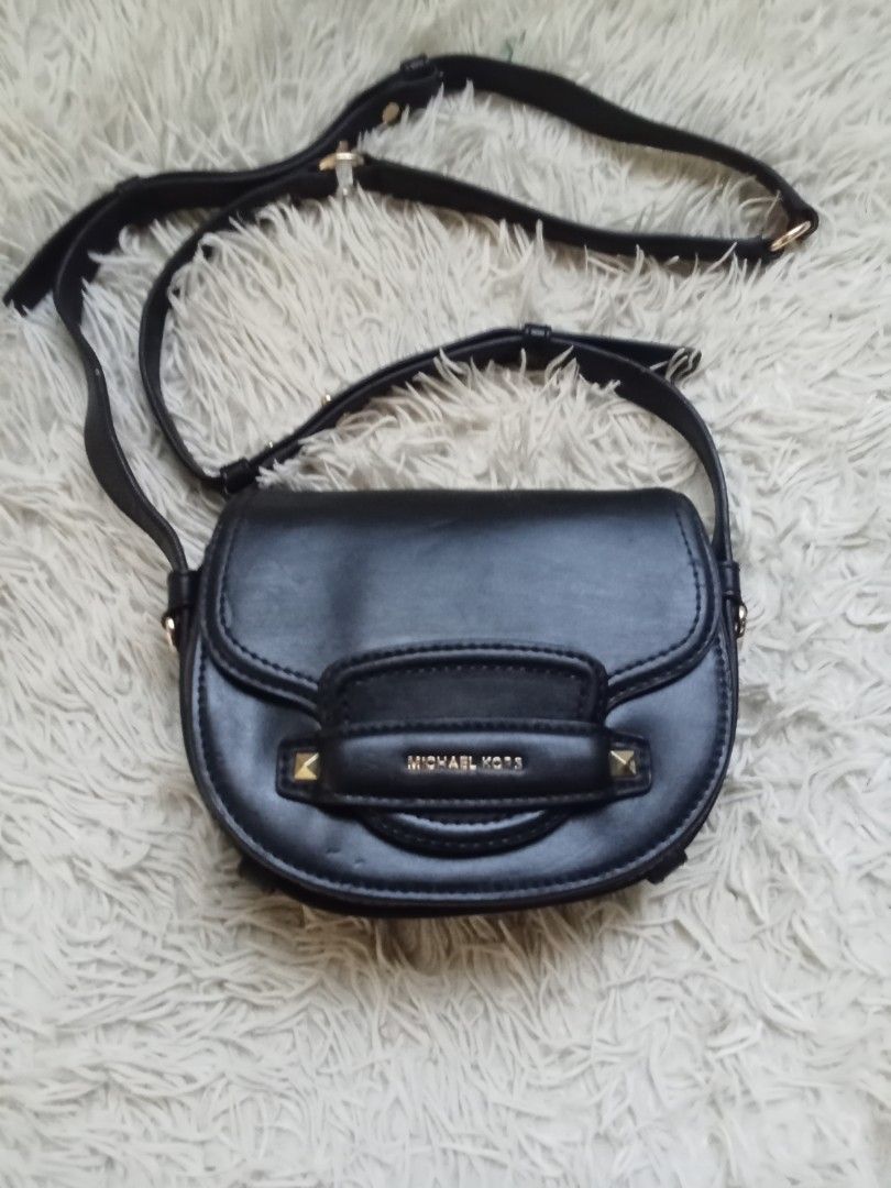 Michael Kors Black Crossbody Bag (Category: Cross-body Bags) located in Caloocan City. Submitted by noy5o1a (Listing ID 1466802577, Image 1). Description: - Brand: Michael Kors - Color: Classic Black - Material: Premium Leather - Hardware: Gold-tone with stylish stud accents - Design: Structured flap front with adjustable shoulder strap - Interior: Clean fabric lining with secure zipped pocket and embossed logo tag .