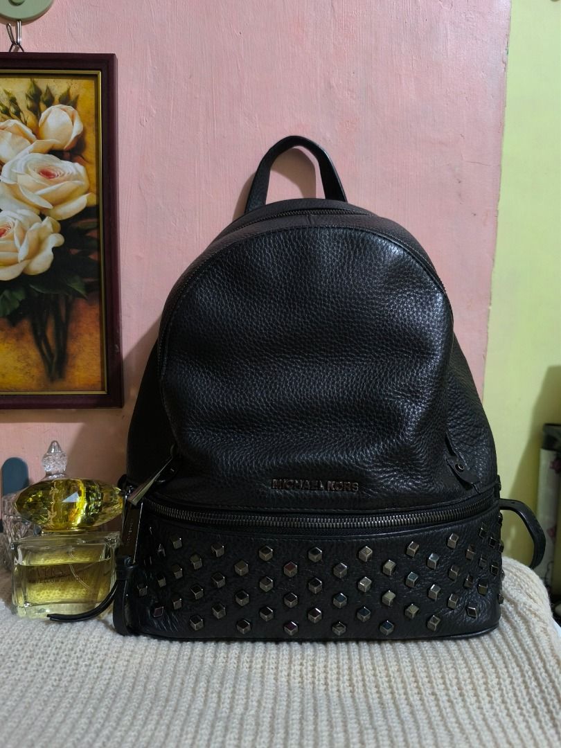 Michael Kors Black Leather Studded Backpack (Category: Backpacks) located in Cebu City. Submitted by re-amoreph_2014 (Listing ID 1466879039, Image 1). Description: - Brand: Michael Kors - Material: Premium black pebbled leather - Hardware: Dark-tone finish - Exterior: Front zip pocket accented with metal studs - Closure: Secure zip-around closure - Interior: Spacious main compartment for daily essentials - Extras: Convenient top grab handle - Con
