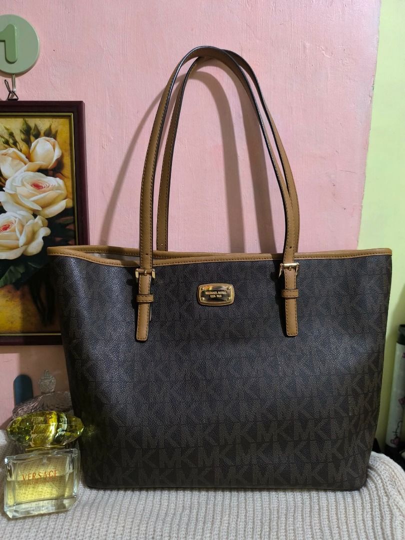 Michael Kors Brown MK Monogram Tote Bag (Category: Tote Bags) located in Cebu City. Submitted by re-amoreph_2014 (Listing ID 1466962298, Image 1). Description: - Authentic brown Michael Kors tote bag with iconic MK monogram print - Features premium tan leather straps, trim, and elegant gold-tone hardware - Stylish buckle details on the handle bases and a front metal logo plaque - Spacious interior designed to easily fit all your daily essentials 
