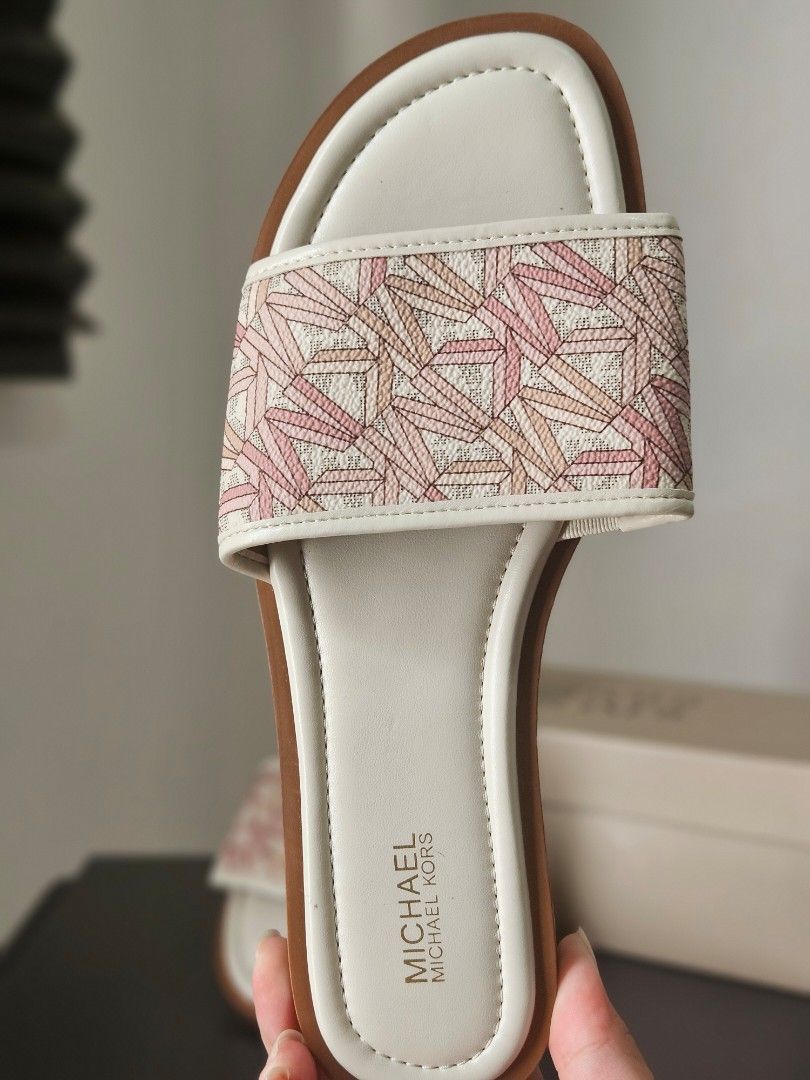 Michael Kors Dana Slides Sandals (Category: Flats & Sandals) located in Quezon City. Submitted by angelafrancescarasos (Listing ID 1466922006, Image 3). Description: - Brand: Michael Kors - Style: Dana slides / slip-on sandals - Size: 6.5 US Women's - Color: White base with pink geometric pattern - Condition: Brand new, never worn, pristine (no box) - Features: Flat sole, MK logo on insole and embossed on bottom - Perfect for: Warm weather and ca