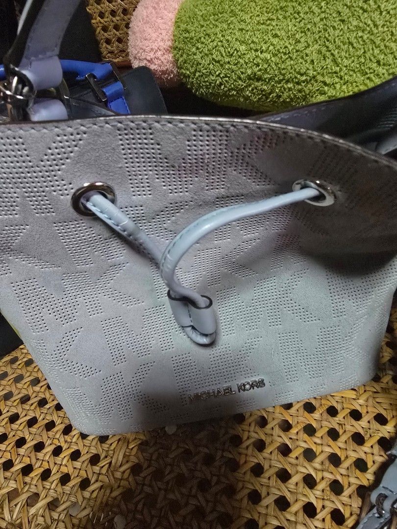 Michael Kors Perforated MK Bucket Bag Light Blue (Category: Luxury Bags & Wallets) located in San Fernando. Submitted by banings (Listing ID 1466797672, Image 1). Description: - Brand: Michael Kors - Color: Light Blue - Material: Soft suede-like fabric with all-over perforated MK logo pattern - Closure: Drawstring closure - Hardware: Silver-tone accents - Branding: Clear metallic logo lettering stamped on the front - Strap: Matching attached shou