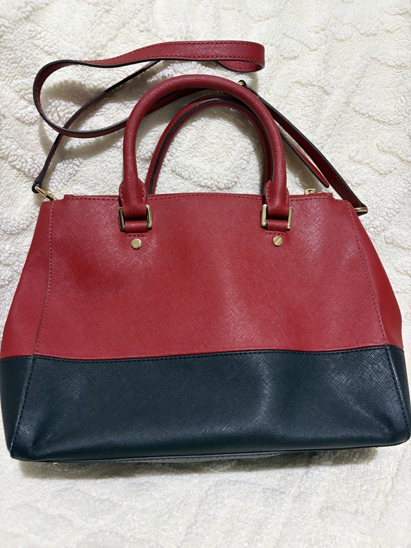 Michael Kors Two-Tone Red and Black Satchel (Category: Luxury Bags & Wallets) located in Paranaque City. Submitted by greatfinds108 (Listing ID 1466835721, Image 2). Description: - Brand: Michael Kors - Material: Premium red and black Saffiano leather - Hardware: Elegant gold-tone with hanging MK charm - Carry options: Double top handles and an adjustable/detachable shoulder strap - Closure: Top zip compartments with a magnetic snap center sectio