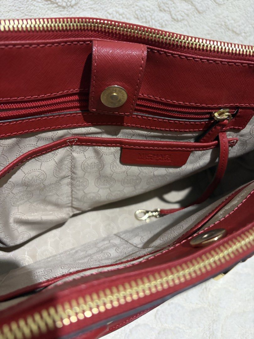 Michael Kors Two-Tone Red and Black Satchel (Category: Luxury Bags & Wallets) located in Paranaque City. Submitted by greatfinds108 (Listing ID 1466835721, Image 3). Description: - Brand: Michael Kors - Material: Premium red and black Saffiano leather - Hardware: Elegant gold-tone with hanging MK charm - Carry options: Double top handles and an adjustable/detachable shoulder strap - Closure: Top zip compartments with a magnetic snap center sectio