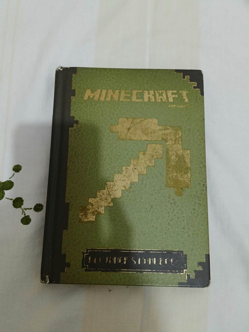 Minecraft Beginner's Handbook Official Guide Mojang Hardcover (Category: Children's Books) located in Paranaque City. Submitted by krishagon11581 (Listing ID 1466929145, Image 1). Description: - Official Mojang Minecraft Beginner's Handbook (Hardcover) - Stylish green faux-leather cover with gold foil pickaxe design and embossed lettering - Essential guide for early edition gameplay mechanics, crafting recipes, and survival tips - Condition: Show