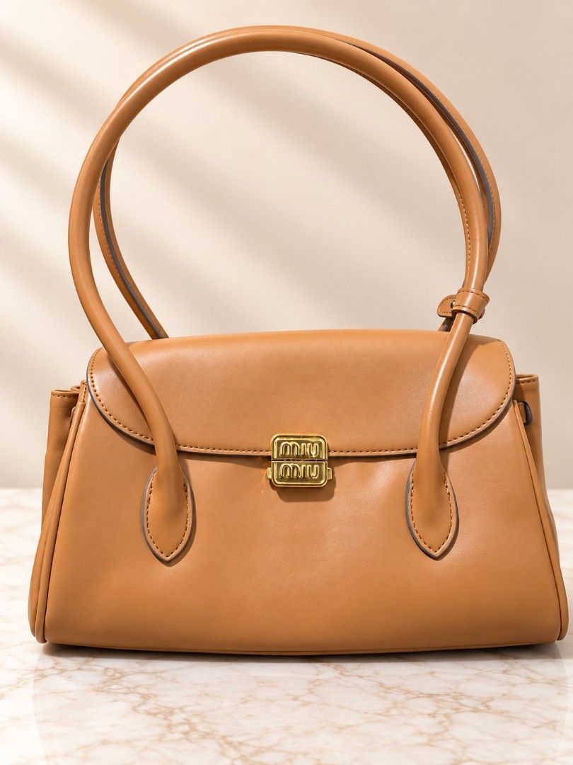 Miu Miu Caramel Leather Shoulder Bag (Category: Shoulder Bags) located in Manila. Submitted by coolbear.5772e6 (Listing ID 1466863543, Image 1). Description: - Brand: Miu Miu - Color: Caramel Brown - Material: Smooth leather with clean edge stitching - Hardware: Gold-tone metal logo clasp - Design: Structured shape with front flap closure - Handles: Dual rounded top handles with buckle detail - Versatility: Timeless style ideal for daily wear or 