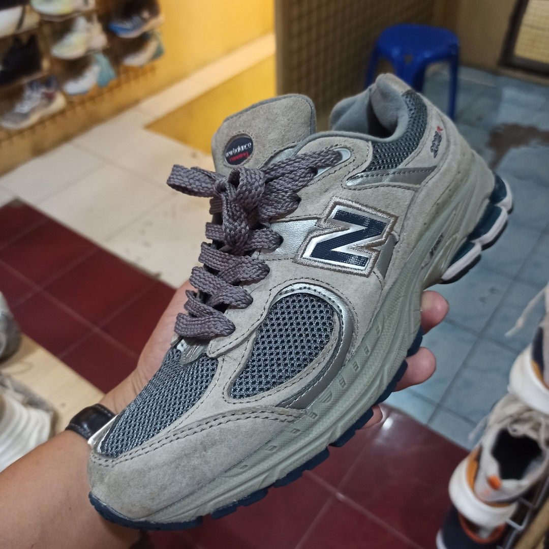 New Balance 2002R Grey Sneakers (Category: Sneakers) located in Tagbilaran City. Submitted by delasierra39181 (Listing ID 1466851577, Image 2). Description: Grey New Balance 2002R running shoes. Classic mesh and suede upper construction with navy blue 'N' branding on the sides. Chunky grey midsole with blue outsole details. Lace-up closure with thick grey laces. Size US 7.5, UK 5.5, EU 38. Made in Vietnam. Normal wear on soles and uppers..