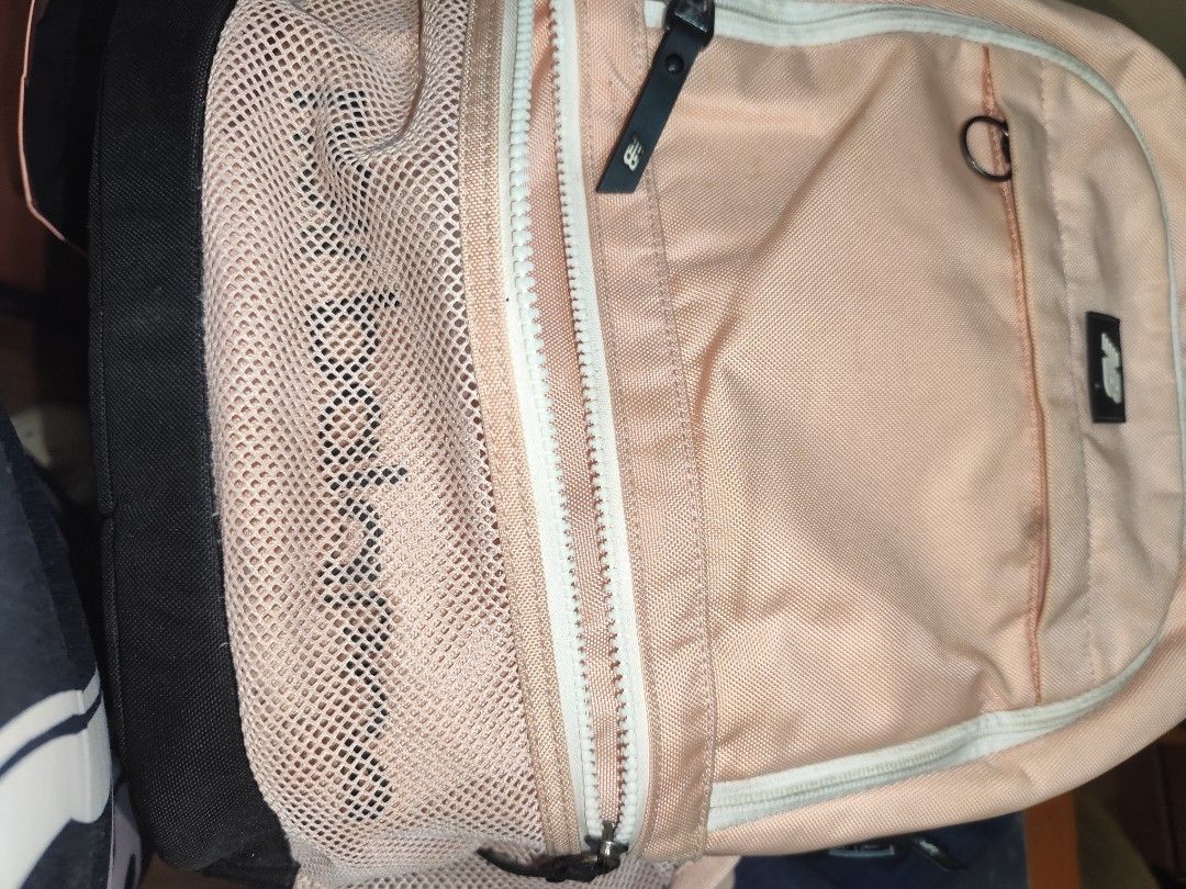 New Balance Peach and Black Backpack (Category: Backpacks) located in Naga. Submitted by semflewer (Listing ID 1466830231, Image 2). Description: Peach colored New Balance backpack with black base and straps. Mesh front pocket and side water bottle holders. Adjustable black buckles on both sides. Padded back mesh panels for comfort. Multiple zip compartments for organization. Everyday school or travel bag..