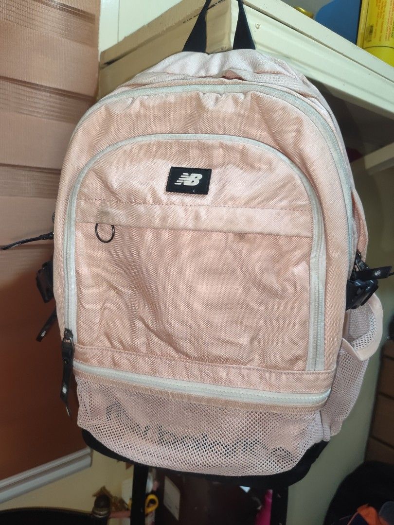 New Balance Peach and Black Backpack (Category: Backpacks) located in Naga. Submitted by semflewer (Listing ID 1466830231, Image 1). Description: Peach colored New Balance backpack with black base and straps. Mesh front pocket and side water bottle holders. Adjustable black buckles on both sides. Padded back mesh panels for comfort. Multiple zip compartments for organization. Everyday school or travel bag..