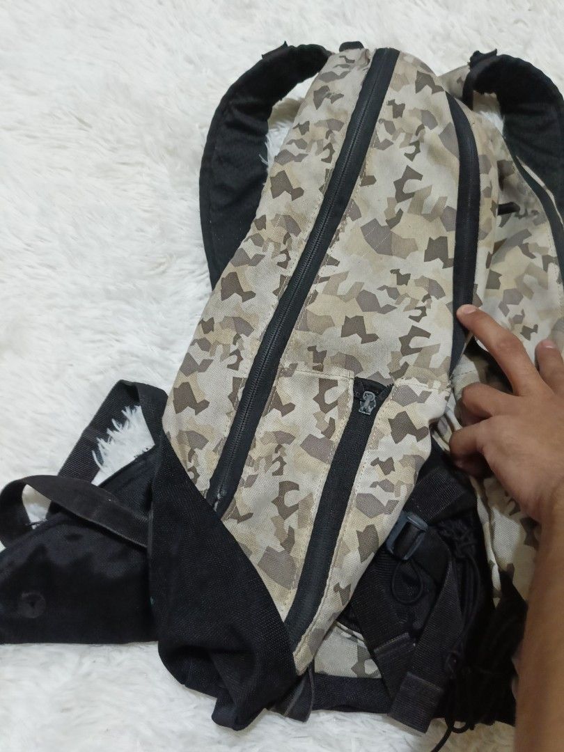 Nike Air Camo Backpack with Padded Straps (Category: Backpacks) located in Quezon City. Submitted by jdwoah12 (Listing ID 1466819784, Image 3). Description: - Tan and brown camouflage print with black accents and straps - Dual zipper main compartment and extra front pockets - Bungee cord detail for extra gear storage - Padded back panel and shoulder straps with waist support - Durable fabric material built for daily use and outdoor trips.